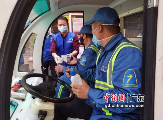 海珠分院医务人员为海珠环卫工人分发消毒水、牙线、牙膏等。 (肖金 摄影)